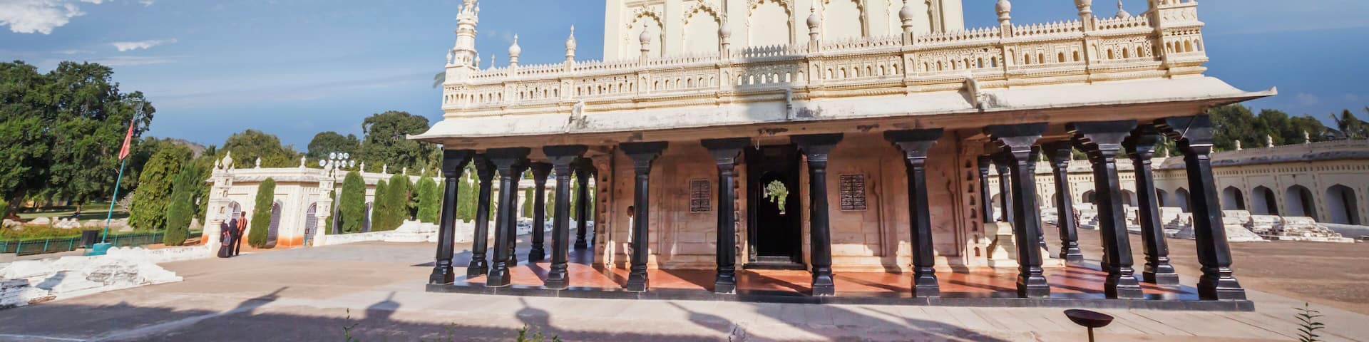 A large, ornate building with a dome and multiple towers, surrounded by a paved area and greenery.