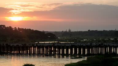 A Mesmerizing Sunset view of an Ancient stone bridge in Silhouette on a river built by the British over a 100 years ago, Picture taken during the golden hour in Karnataka,India.