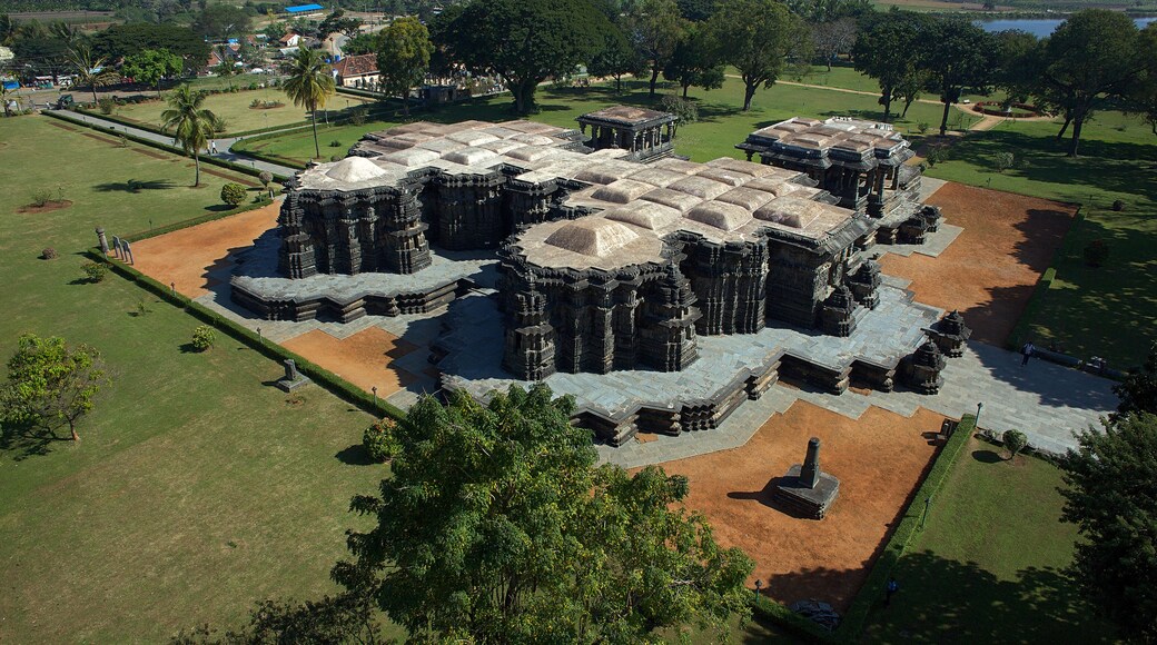 Aerial view of the ancient, elaborately carved Ishvara Temple complex standing majestically amidst lush greenery, Arasikere, Karnataka, India.