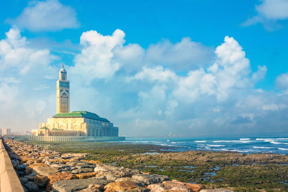 Vista costera con una mezquita destacada y un faro.