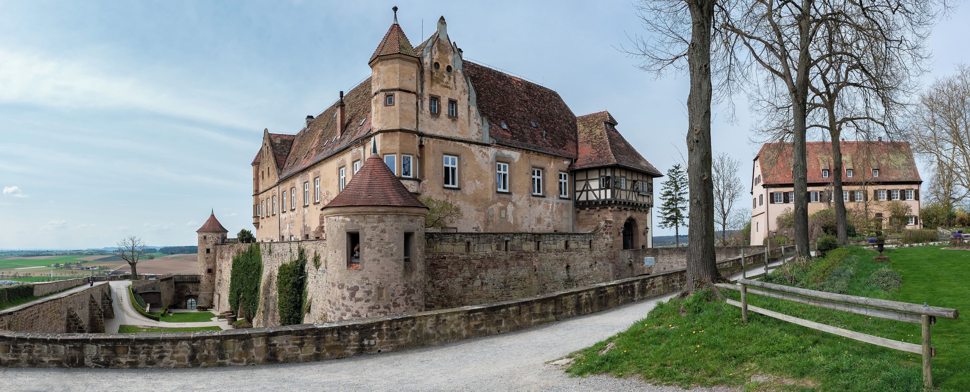 A historic castle with a stone wall and a pathway leading to it.
