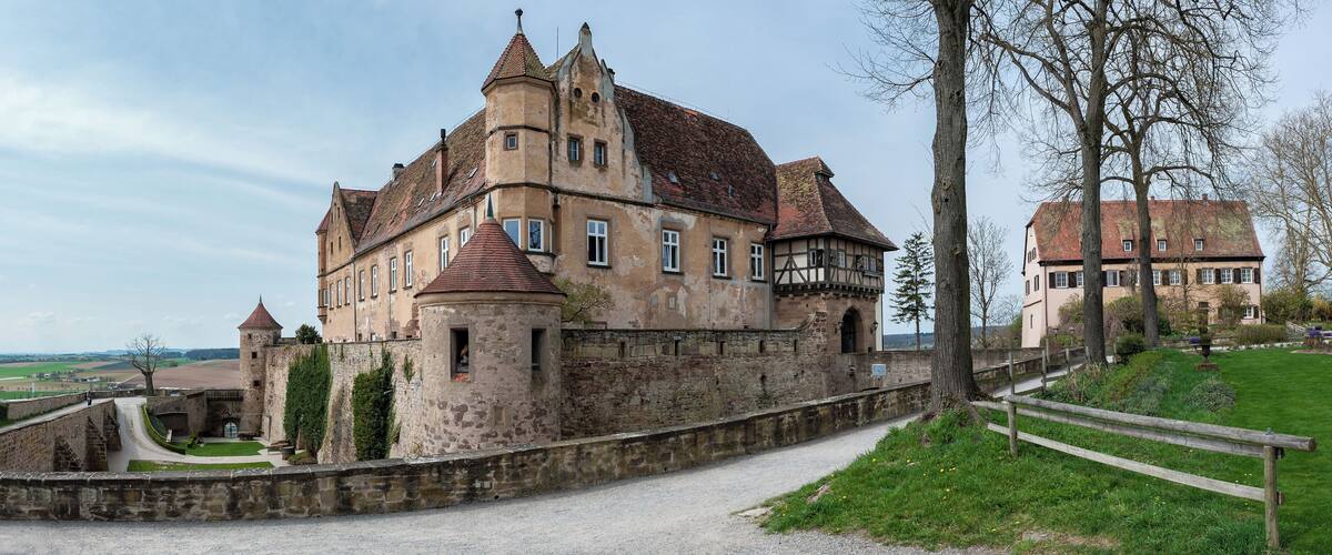 A historic castle with a stone wall and a pathway leading to it.