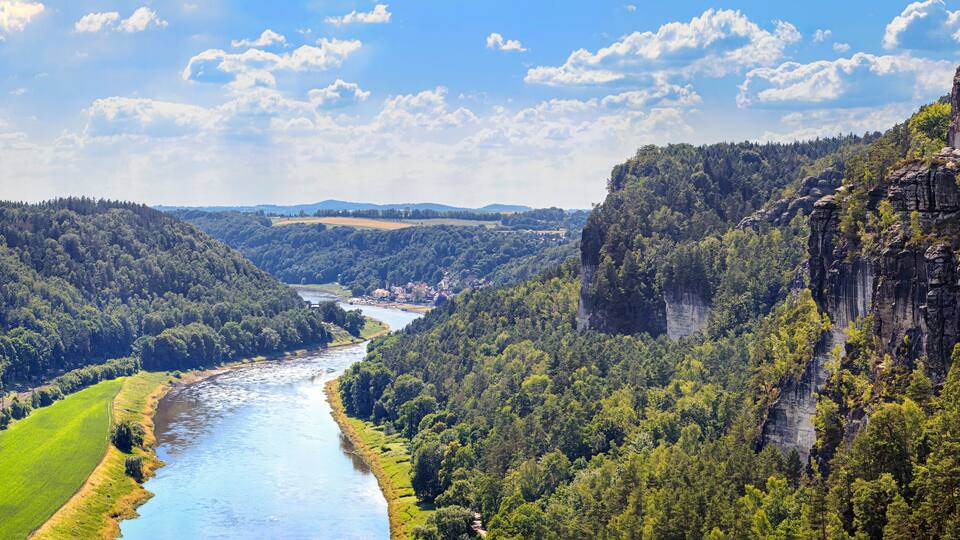 A river winding through a valley with dense forests and rocky cliffs.