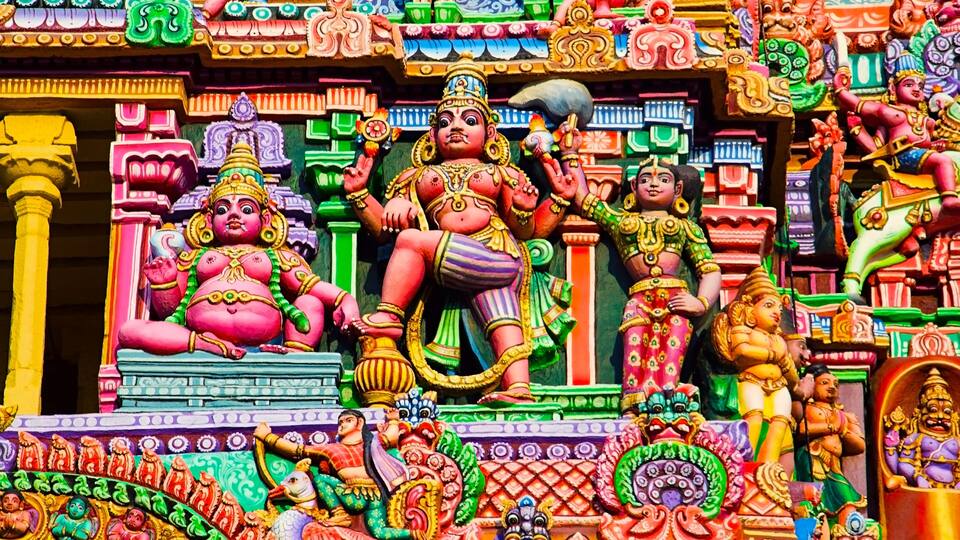 A colorful temple with intricate carvings and statues of deities.