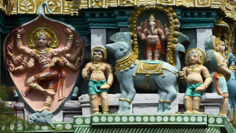 A temple with colorful statues of deities and elephants.