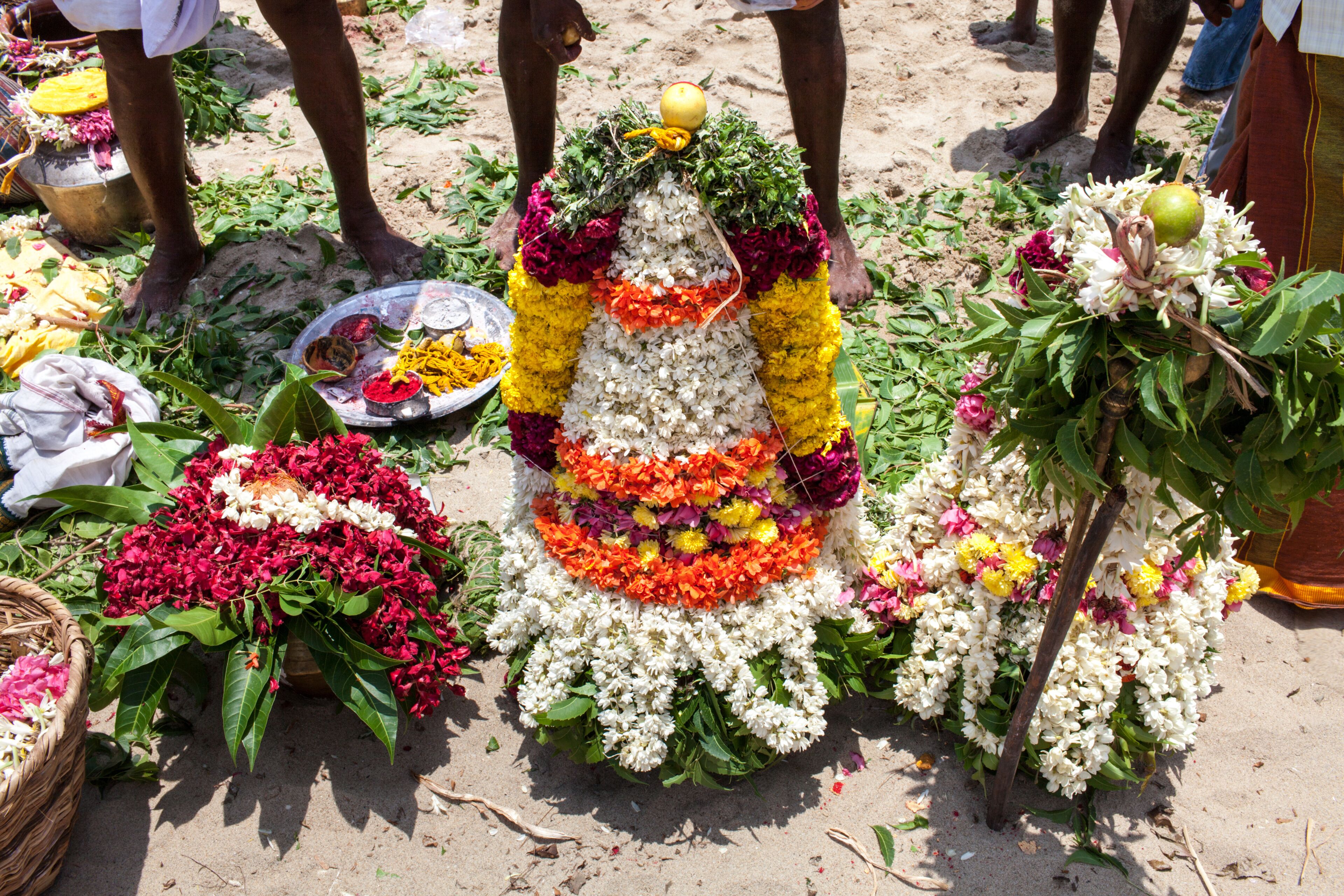 A floral arrangement with a central white flower, surrounded by vibrant colors and greenery.