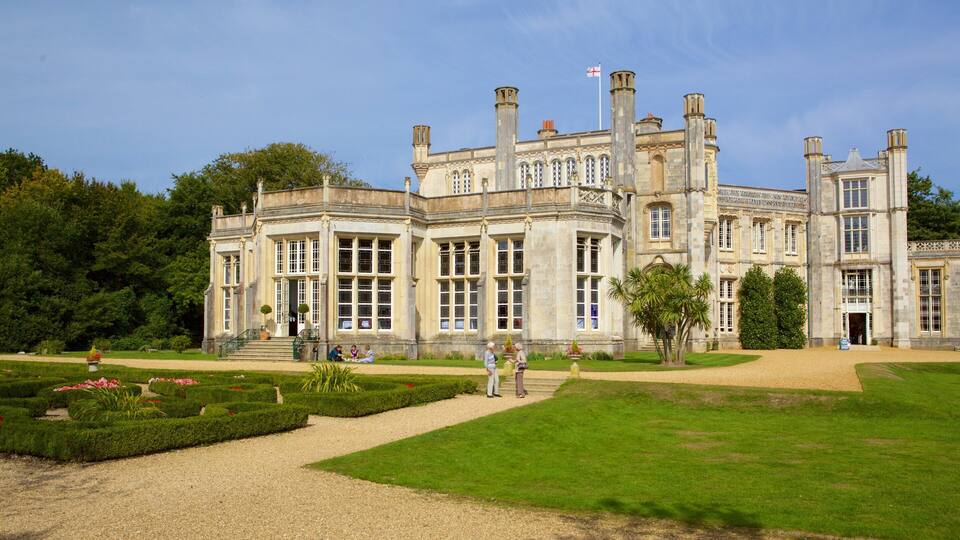 A historic building with large windows and a formal garden.