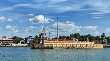 A temple complex by a river with a clear sky.