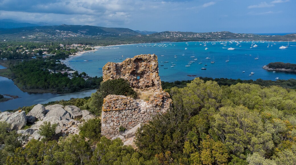 Aerial view of the remains of the square-shaped Genoese Tower of Cala Rossa overlooking the beach of Saint Cyprien in the South of Corsica, France