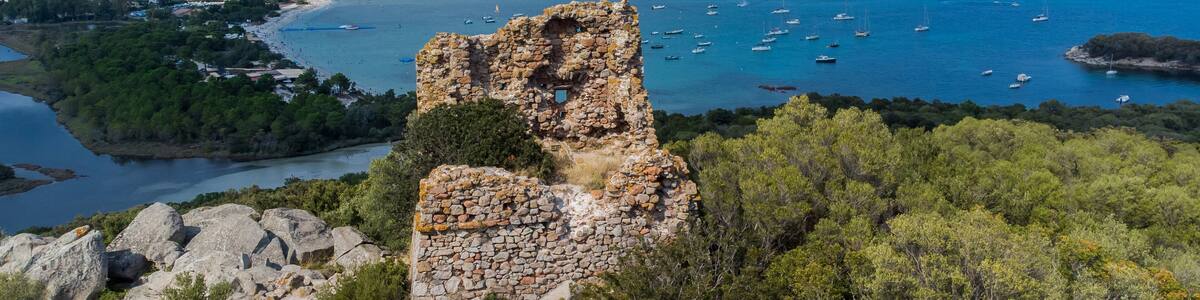 Aerial view of the remains of the square-shaped Genoese Tower of Cala Rossa overlooking the beach of Saint Cyprien in the South of Corsica, France