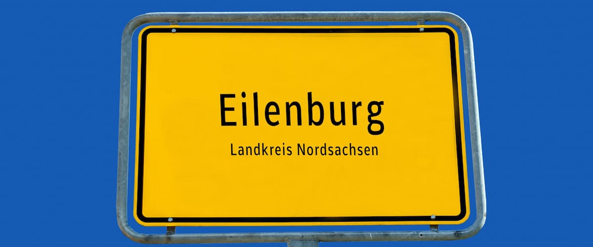 A yellow sign with the text "Eilenburg" and "Landkreis Niedersachsen" against a blue sky.