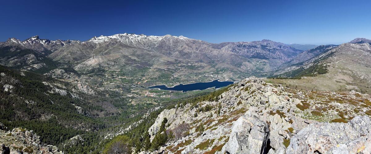 A mountainous landscape with a lake and rocky terrain.
