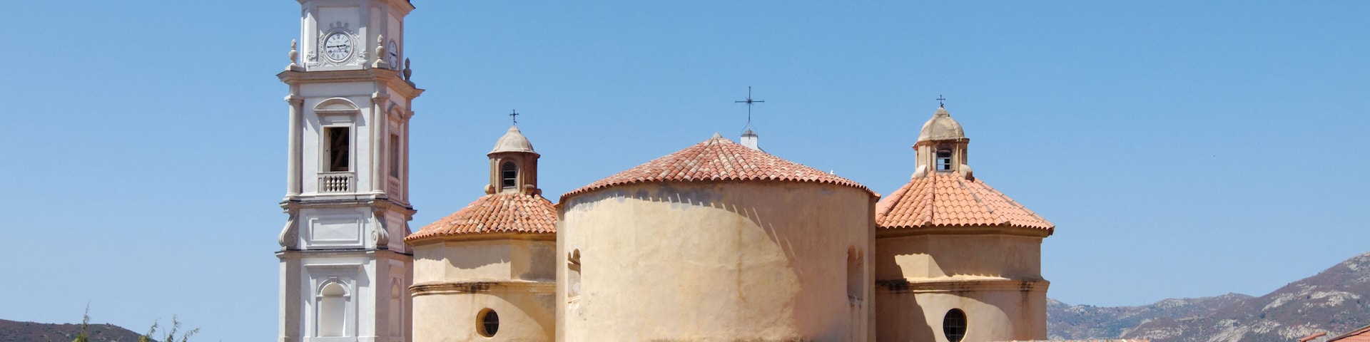 A church with a bell tower and domed roofs.
