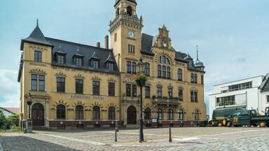 A historic building with a clock tower and a sign reading "Kaiserliches Postamt".