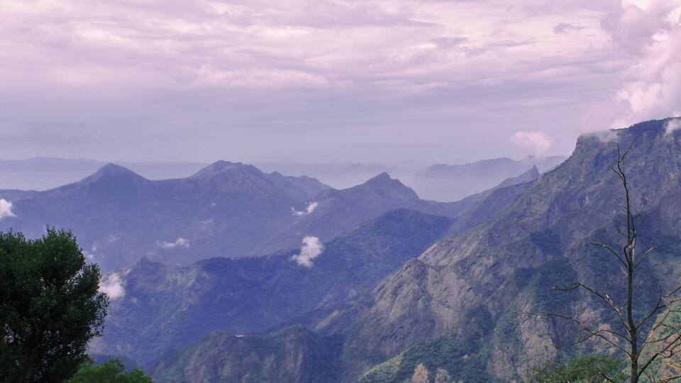 A mountainous landscape with rugged terrain and a cloudy sky.
