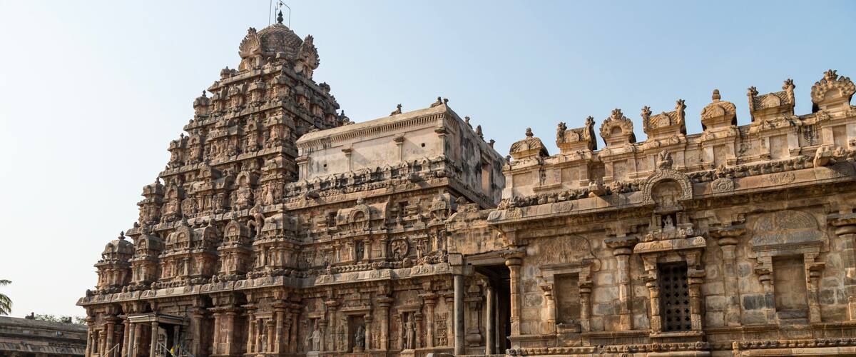 A large, intricately carved temple with detailed sculptures and a large staircase leading up to the entrance.