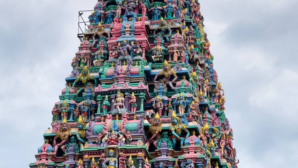 A multi-tiered temple with colorful statues and intricate carvings.