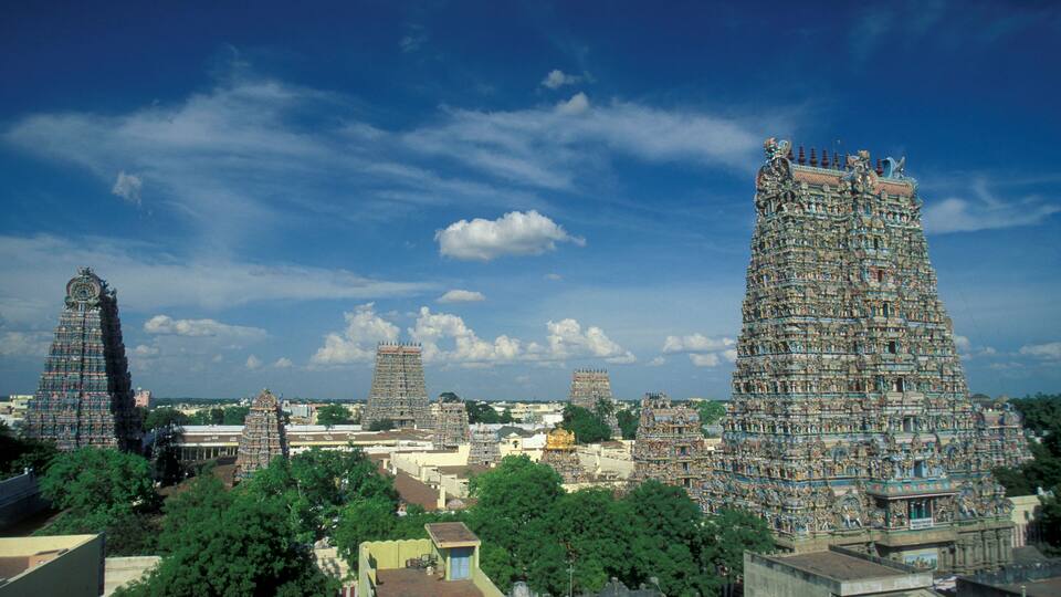 A temple complex with multiple tiered towers and lush greenery.