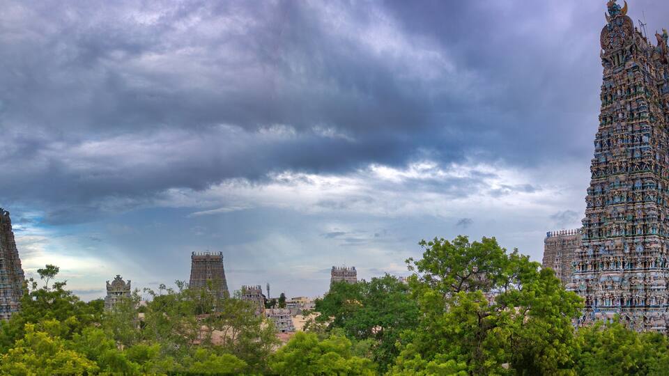 A temple complex with multiple tiered towers under a cloudy sky.