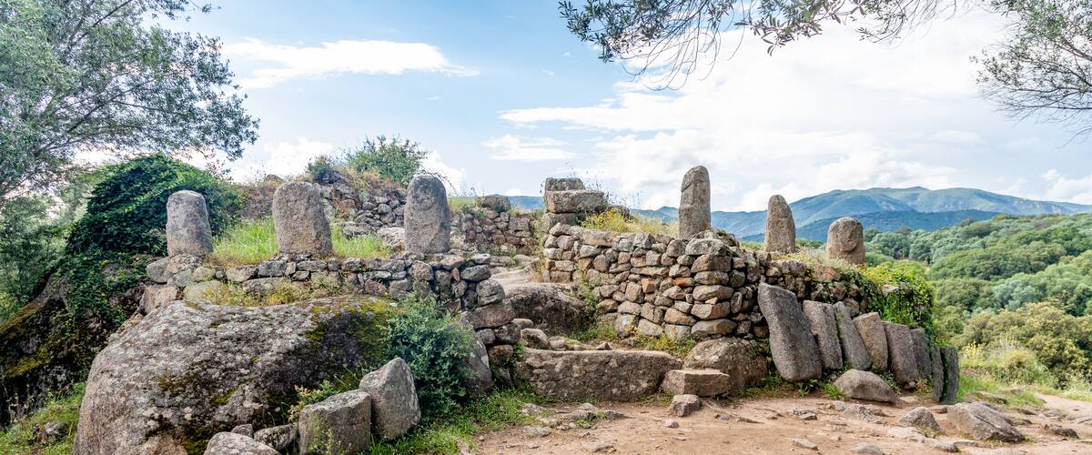 Ancient stone ruins with a mountainous backdrop.