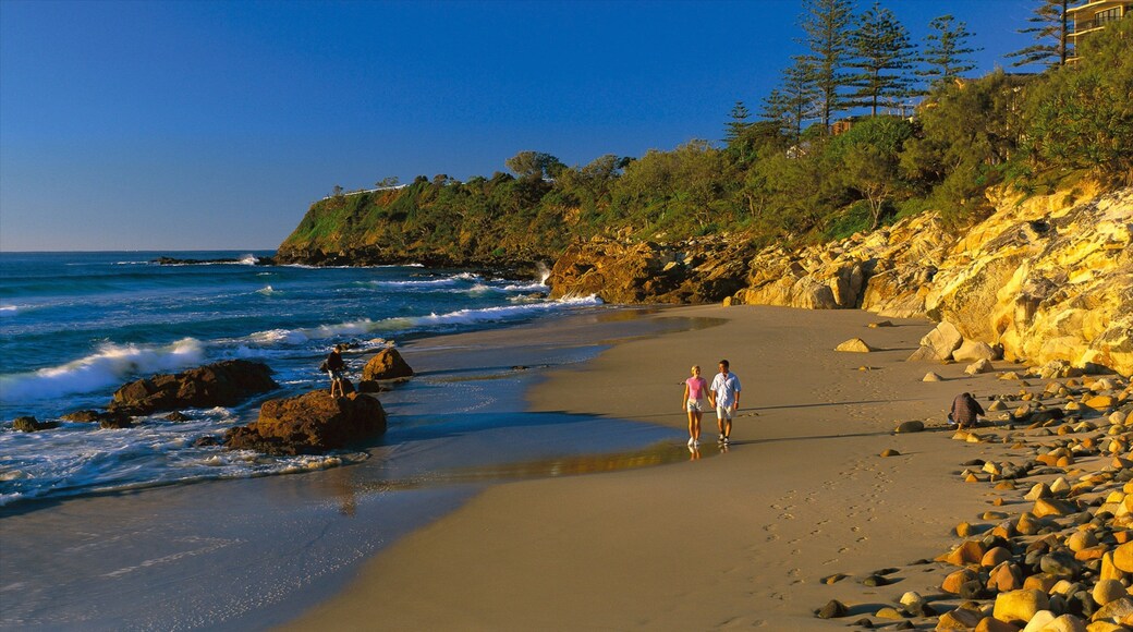 Coolum Beach featuring a sandy beach and rocky coastline as well as a couple