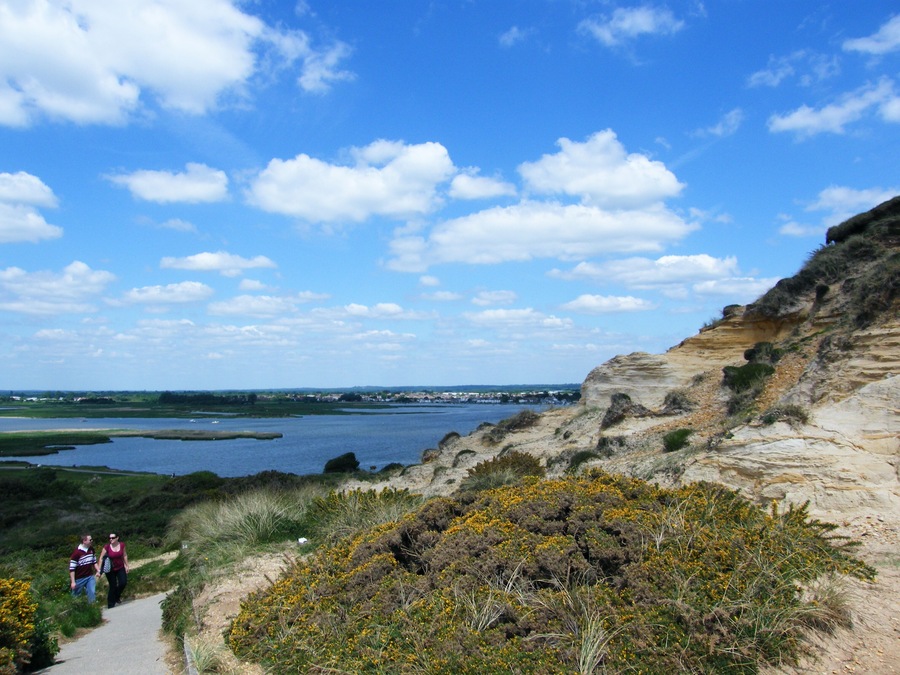 A coastal landscape with cliffs, a path, and a body of water.