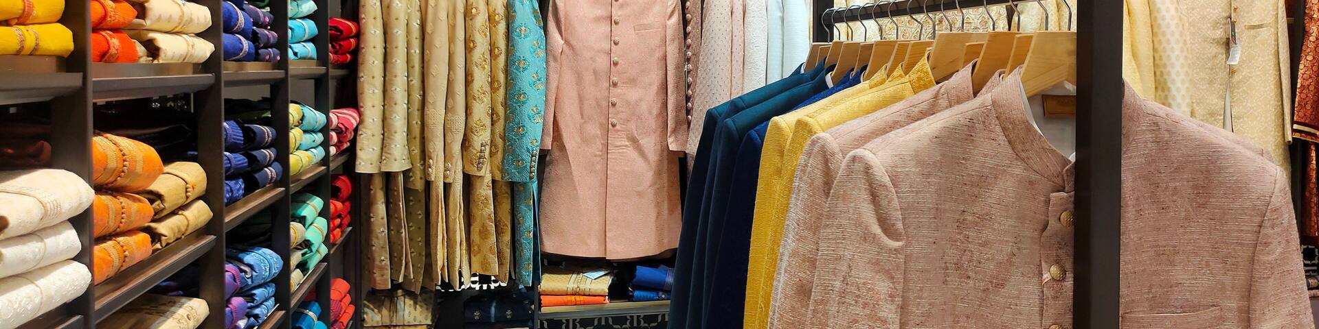 Pune ,INDIA, 2 October 2021 : Indian men latest fashion dress hung on hangers, in display in retail shop in market, wedding wear for men India