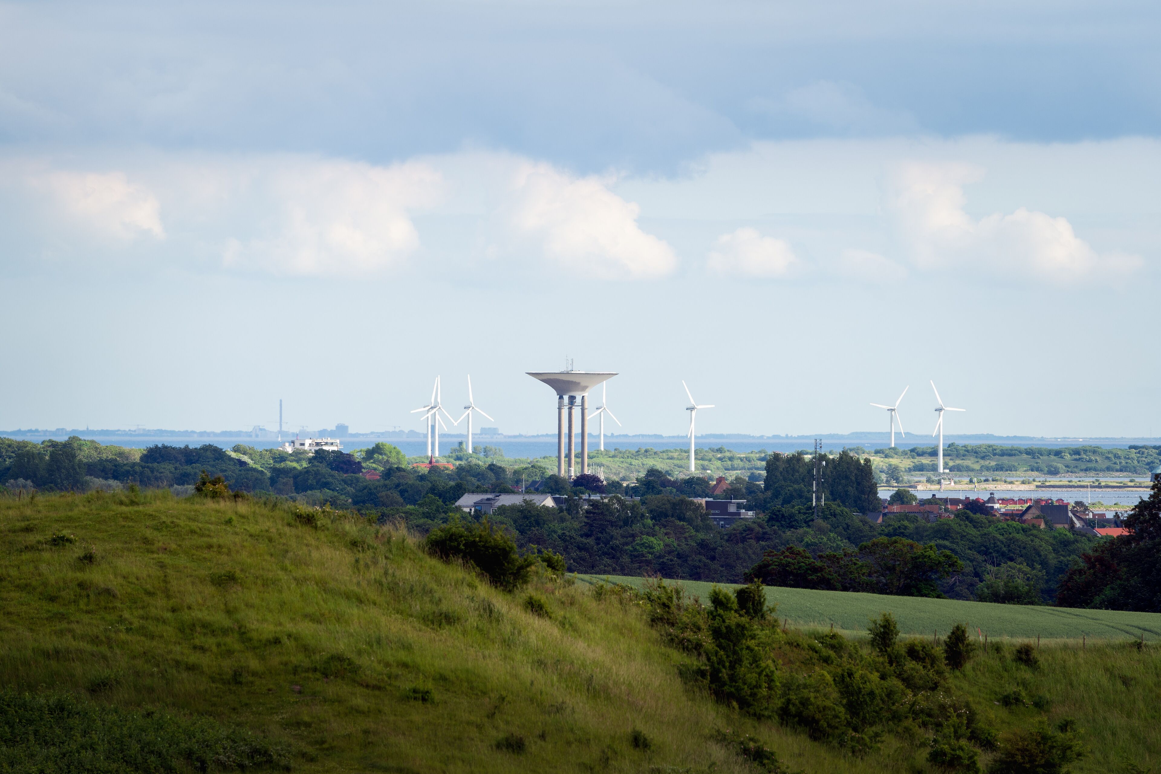Cityscape with Landskrona water tower and wind turbines seen from Glumslov in Sweden. Selective focus.