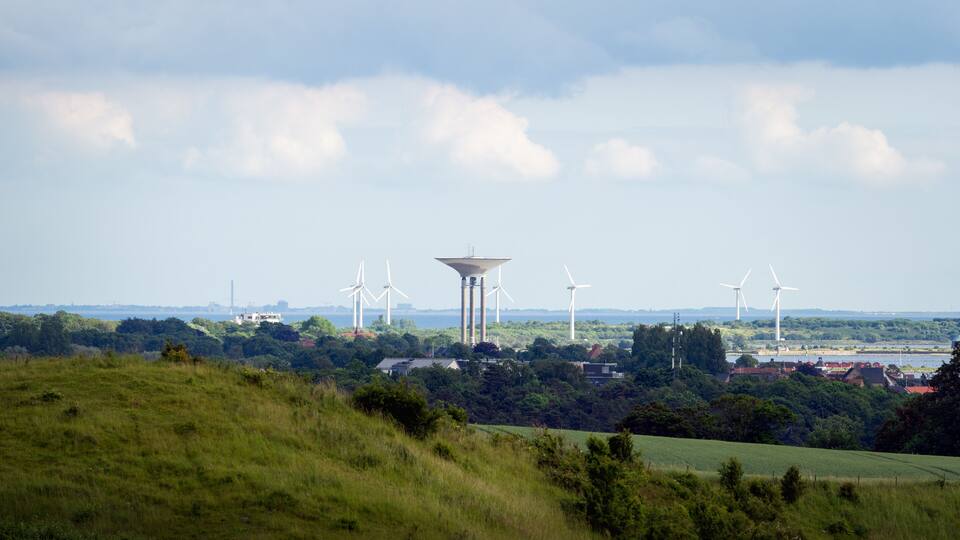A landscape with wind turbines and a water tower.