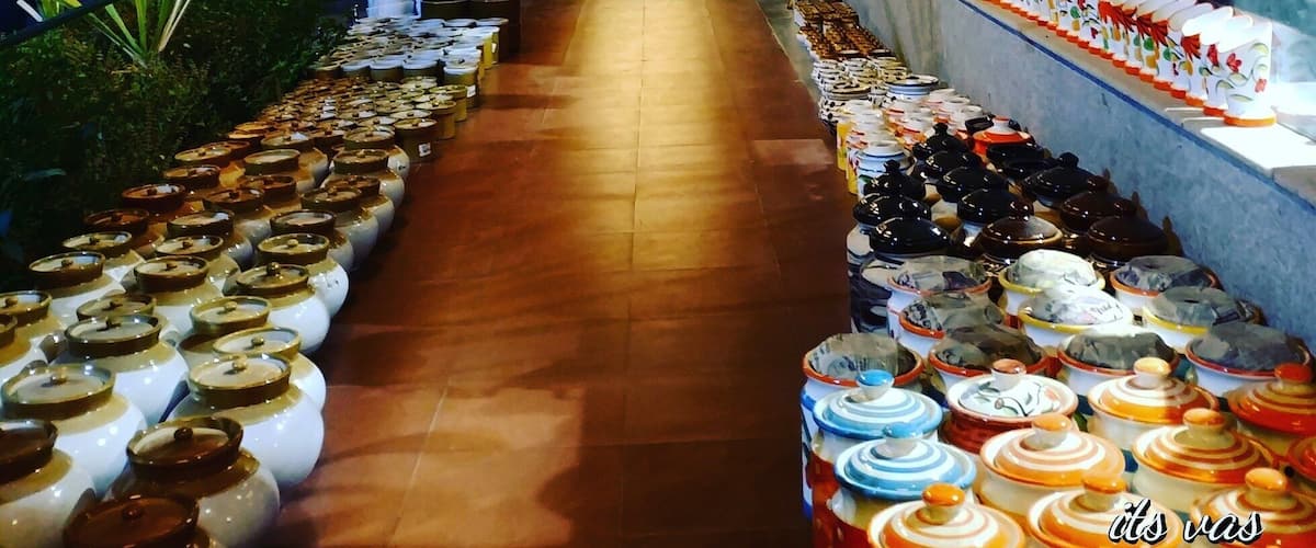 A corridor with shelves of jars and decorative items, illuminated by warm lighting.