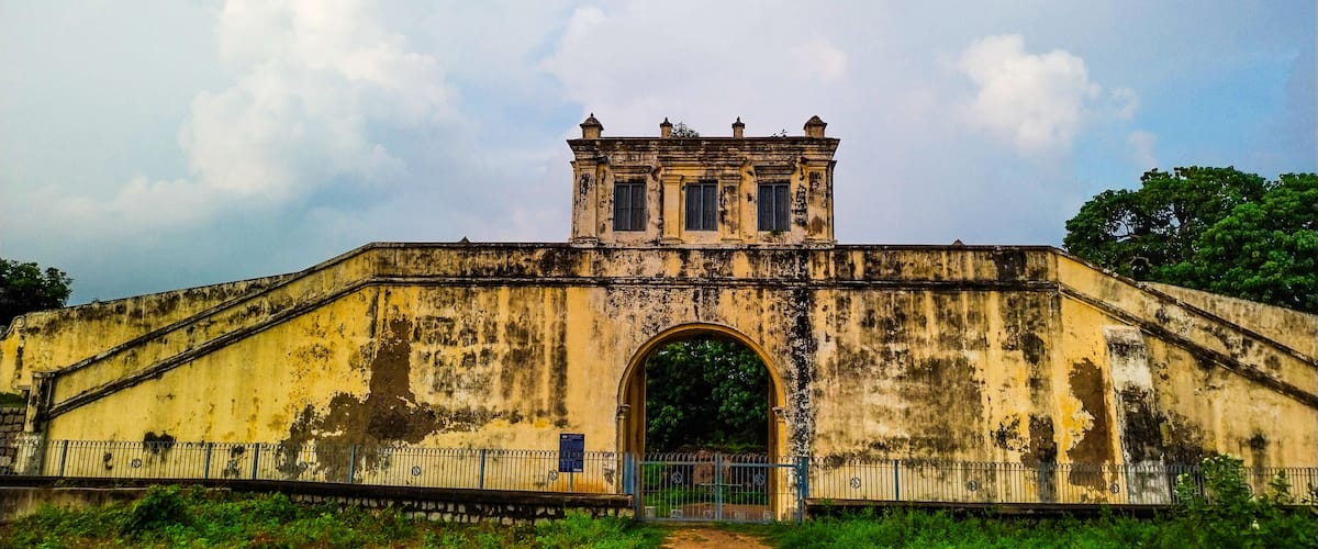 An old, weathered bridge with a central archway and a small tower on top.