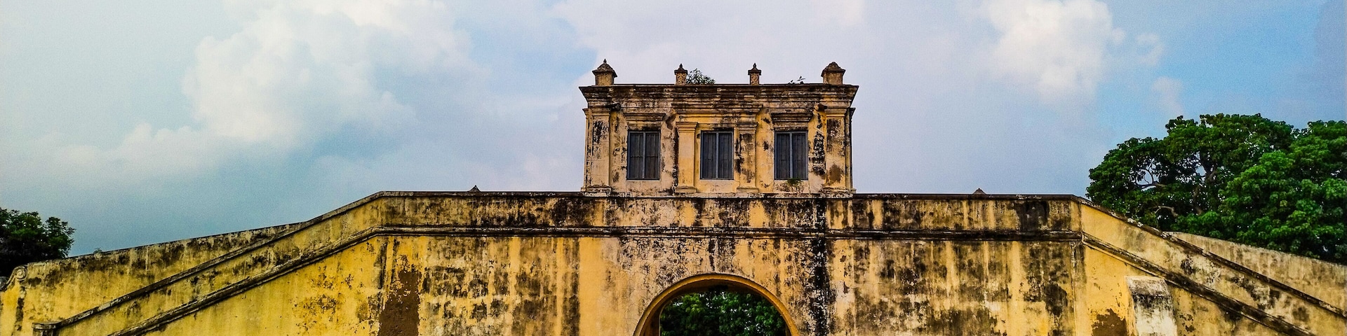 An old, weathered bridge with a central archway and a small tower on top.