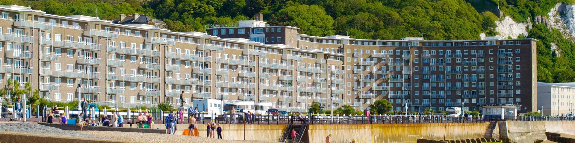 Dover Beach showing a beach and heritage architecture as well as a large group of people