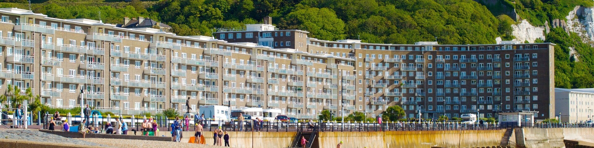 Dover Beach showing a beach and heritage architecture as well as a large group of people