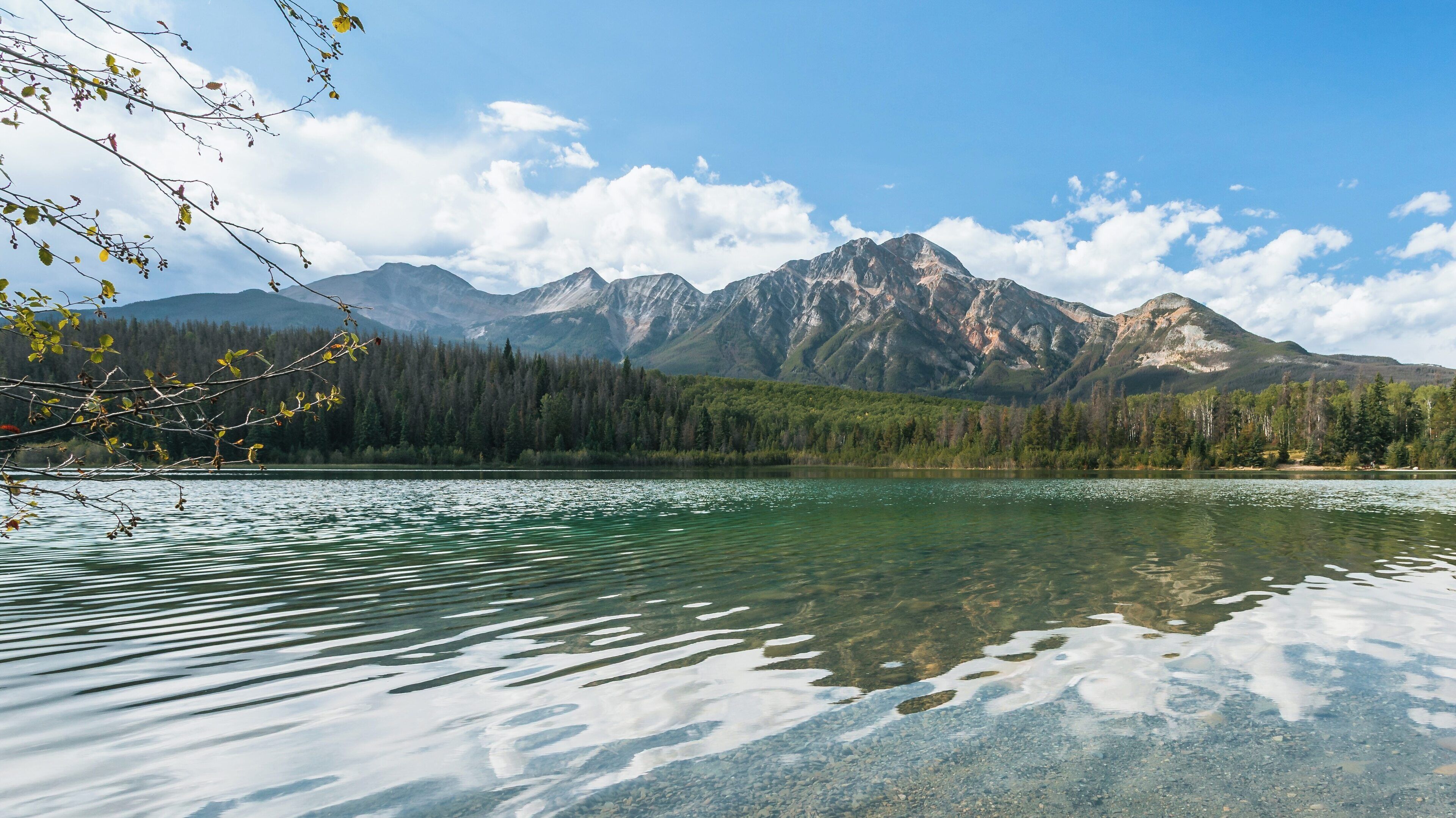 Stunning view of Patricia Lake framed by majestic mountains in Jasper, Alberta, showcasing serene waters and a vibrant sky