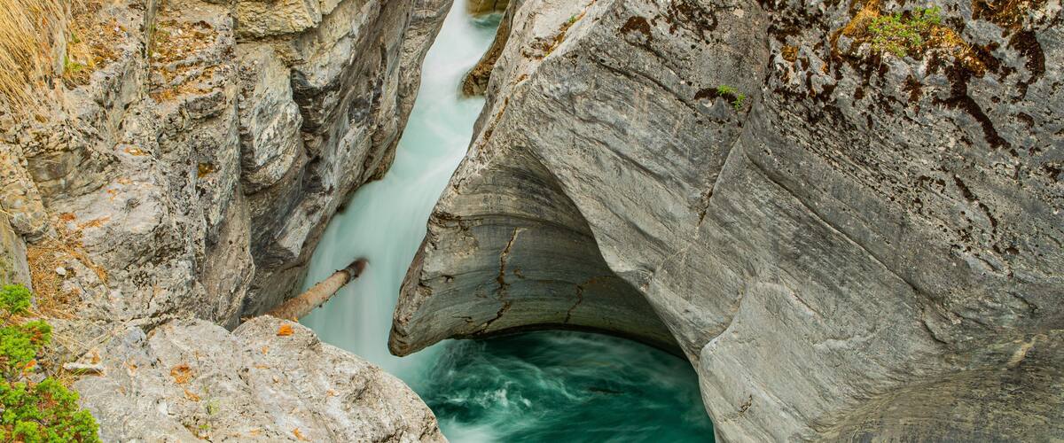 Maligne Canyon featuring a river or creek, a waterfall and rapids