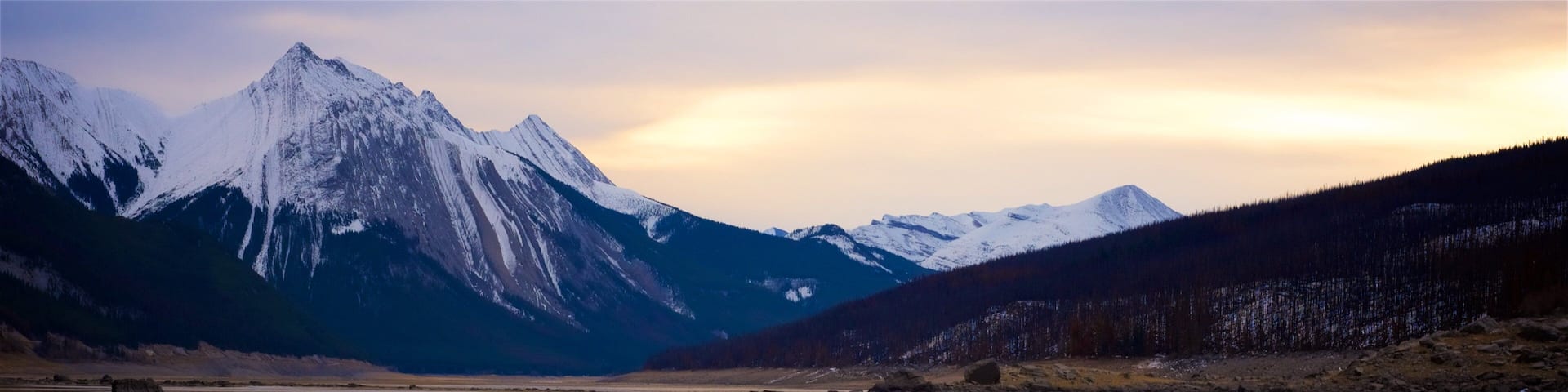 Medicine Lake featuring mountains, snow and a lake or waterhole