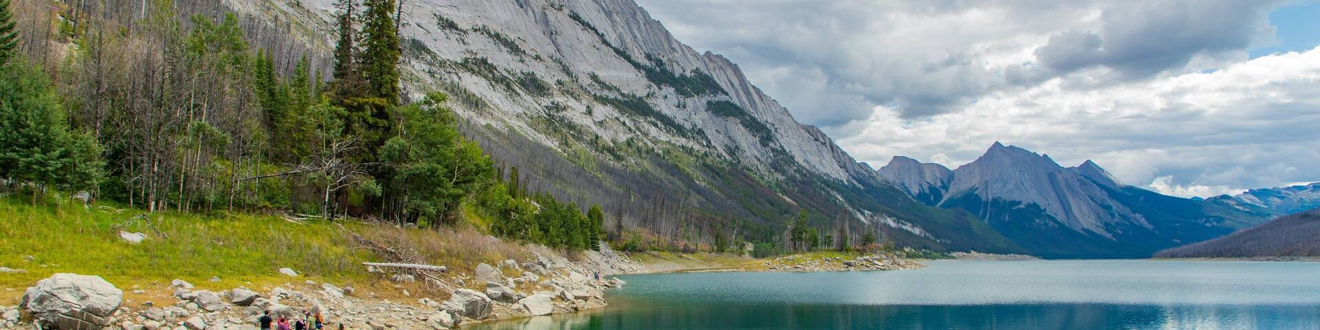 A clear mountain lake surrounded by rocky shores and dense forests.