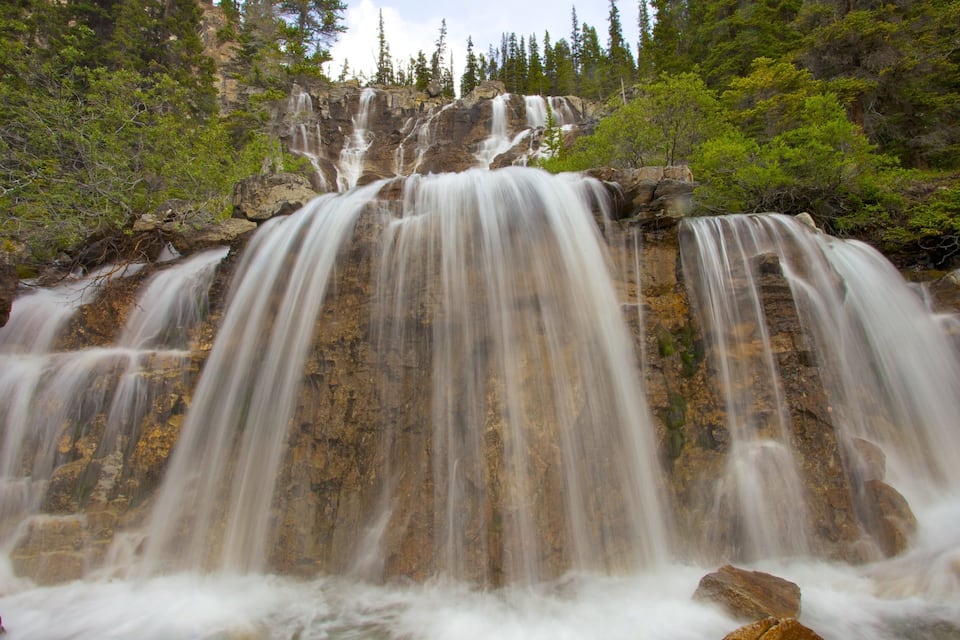 Une cascade à plusieurs niveaux, entourée d’une forêt dense.