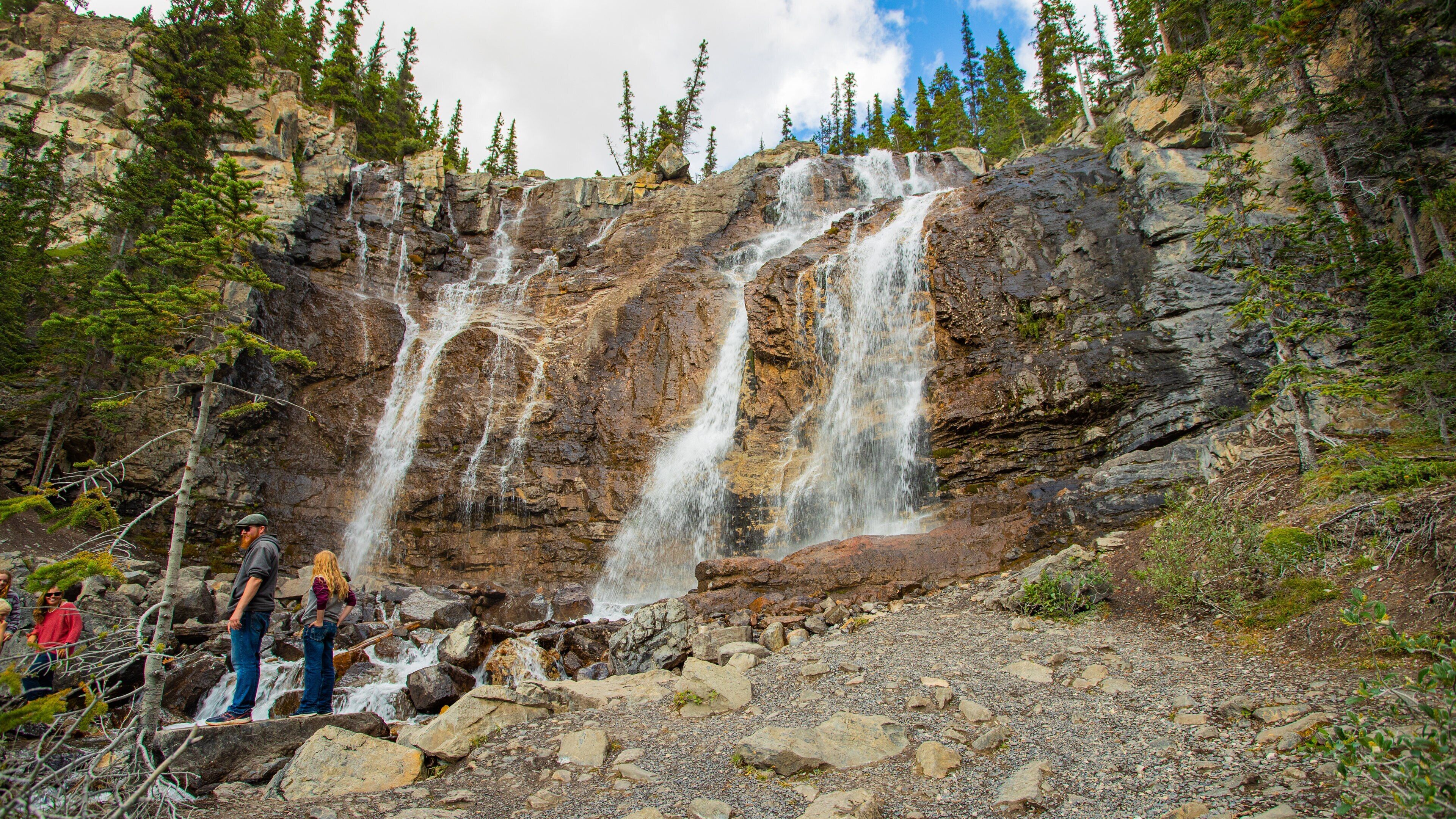 Tangle Falls featuring a cascade and a river or creek as well as a small group of people