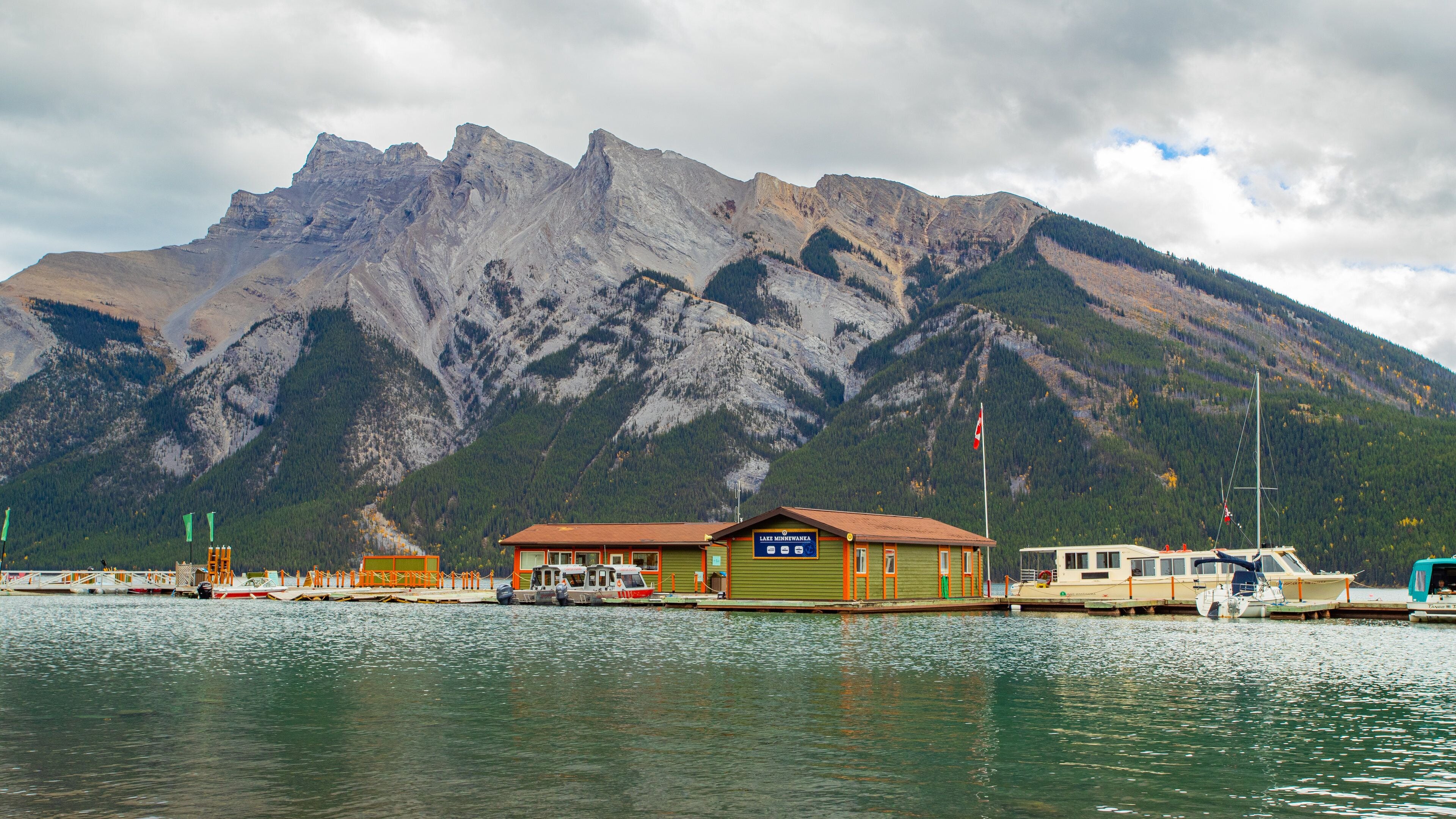 Un chalet au bord du lac, avec une vue sur les montagnes en arrière-plan.
