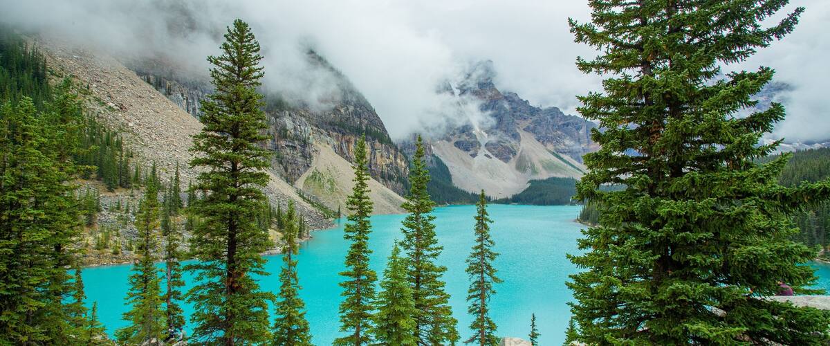 Moraine Lake featuring mist or fog and a lake or waterhole