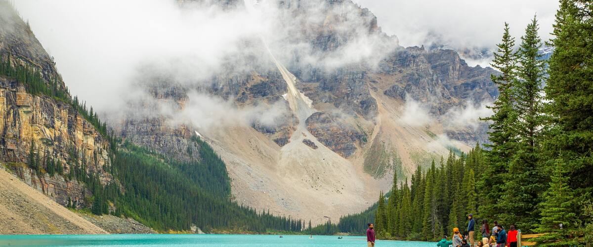 Moraine Lake which includes mist or fog, a lake or waterhole and mountains