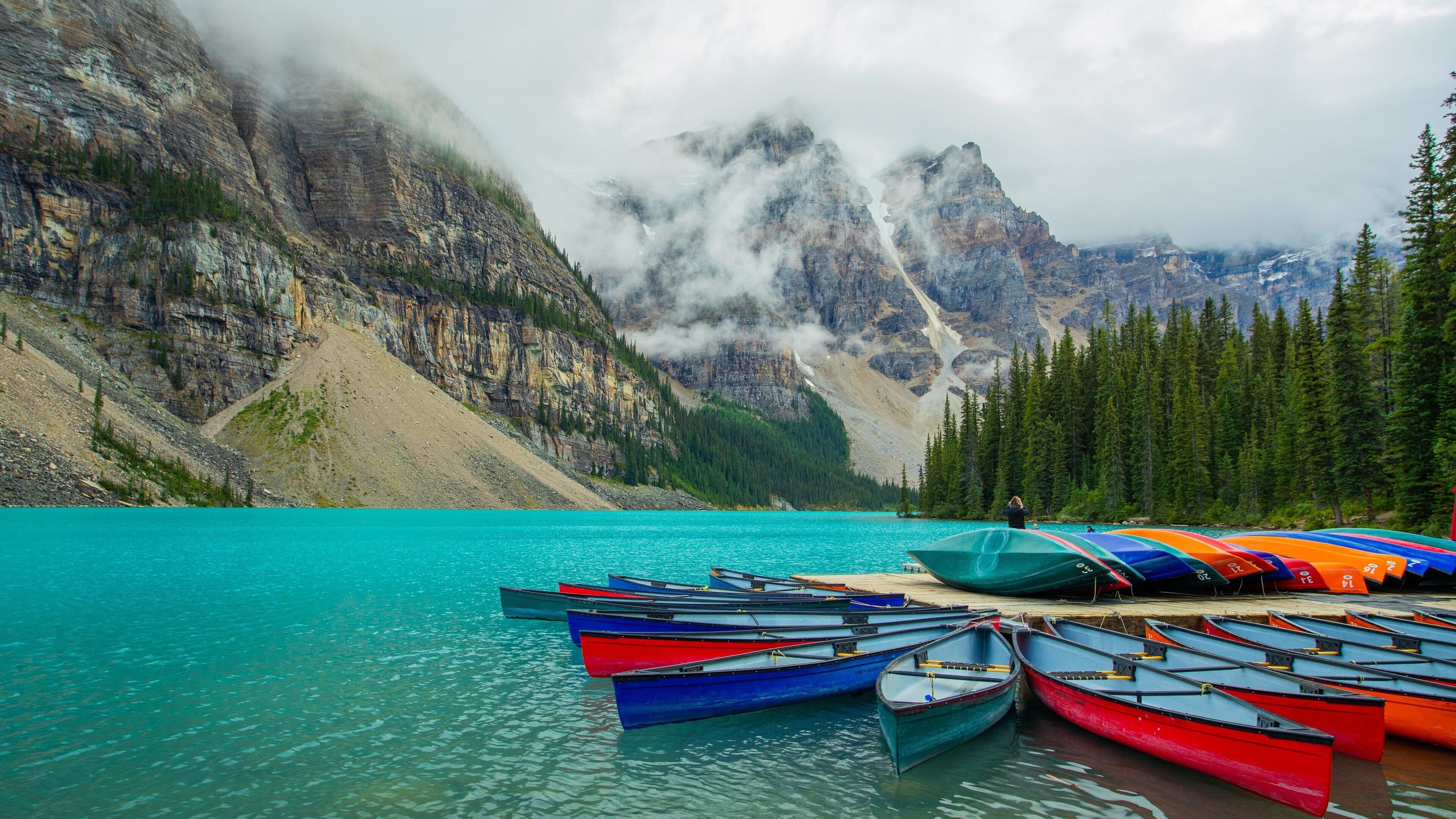 Moraine Lake which includes mist or fog, mountains and a lake or waterhole