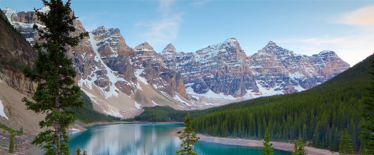 A mountain lake surrounded by snow-capped peaks and dense forests.