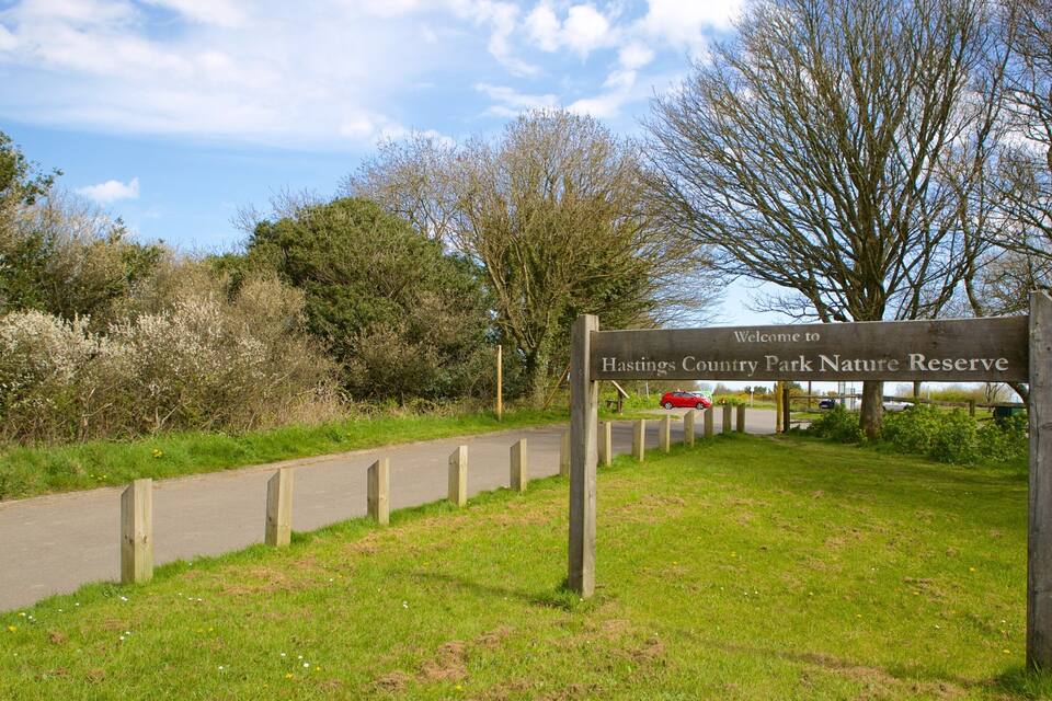 Un senyal de fusta que dóna la benvinguda als visitants al Parc Natural de Hastings Country Park.