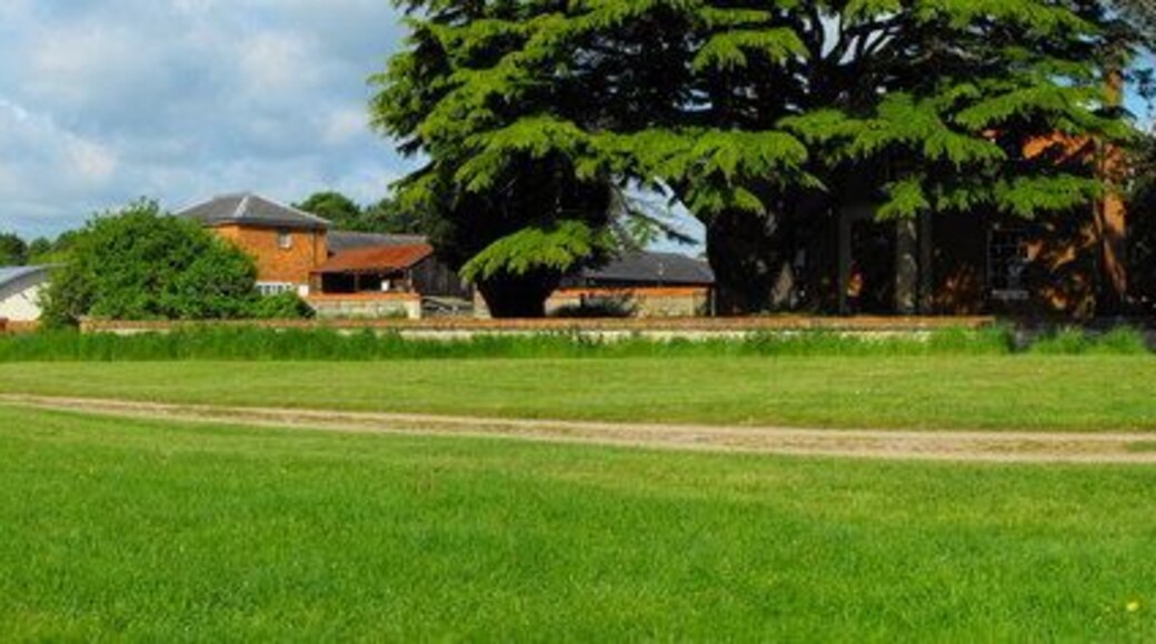 Stacey Hill Farm, Stacey Avenue, Wolverton, Milton Keynes, Buckinghamshire. Built as a model farm in 1848, now converted into Milton Keynes Museum. The farmhouse is behind the large cedar tree on the right of the photo. Across the middle of the view is the retaining wall of a ha-ha. The modern building on the left houses a restored tramcar that used to run between Stony Stratford and Wolverton.
