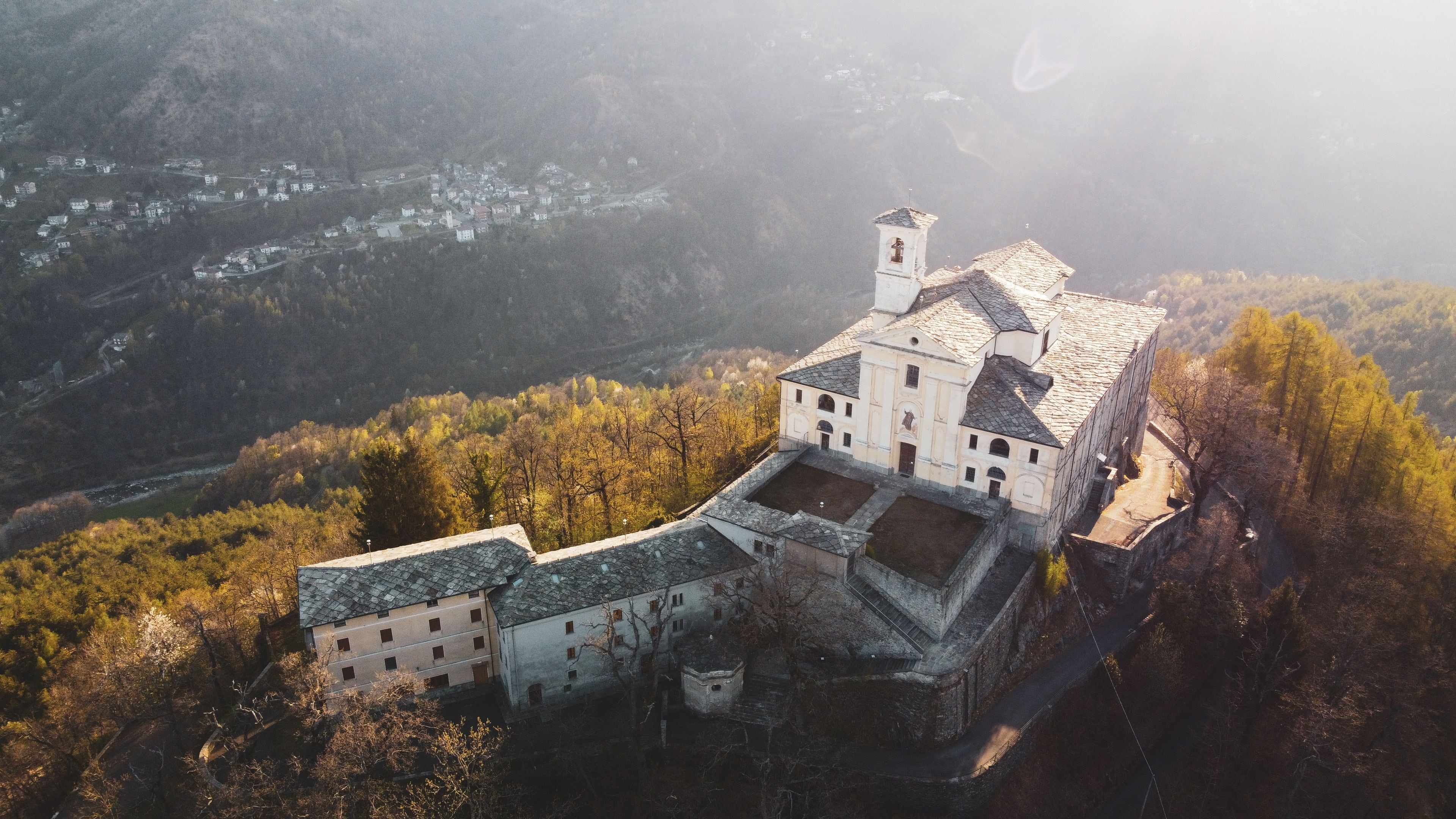 A castle surrounded by forested hills.
