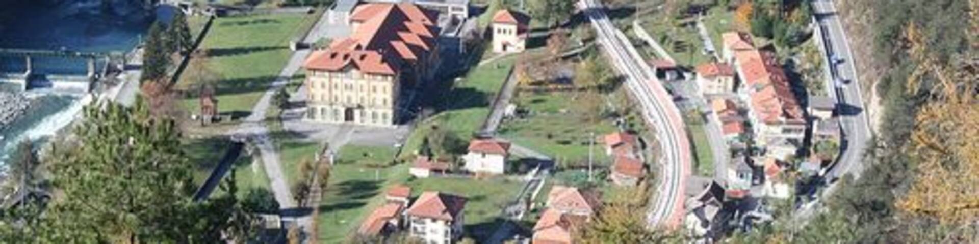 A river winding through a town with buildings and a bridge.
