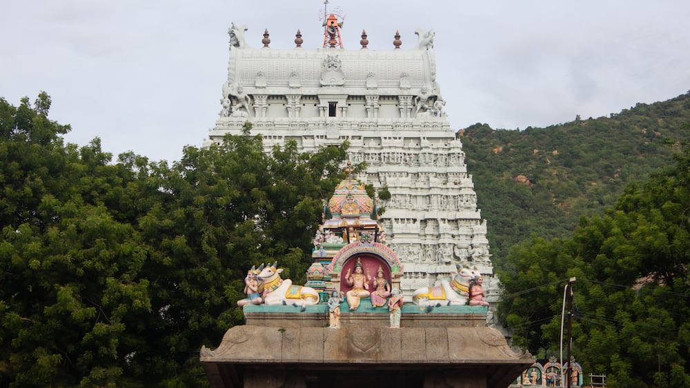 A temple with intricate carvings and a large statue on top.